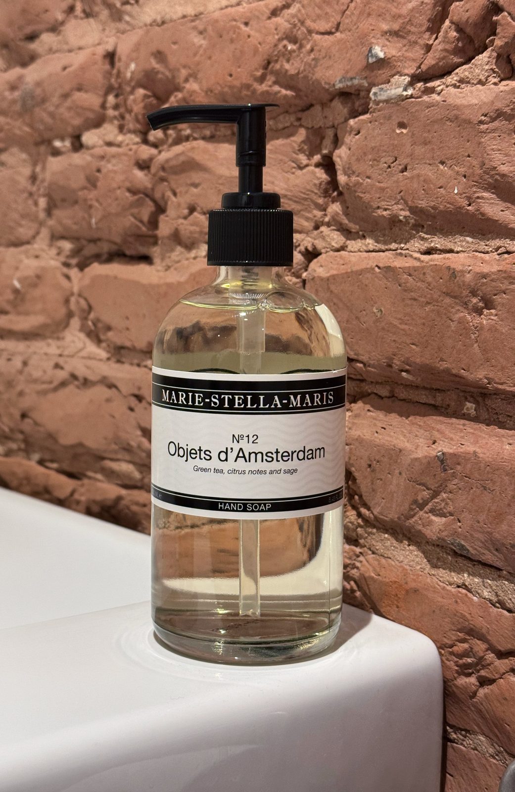 Marie-Stella-Maris Objets d'Amsterdam hand soap on a white basin against an exposed brick wall at Waal