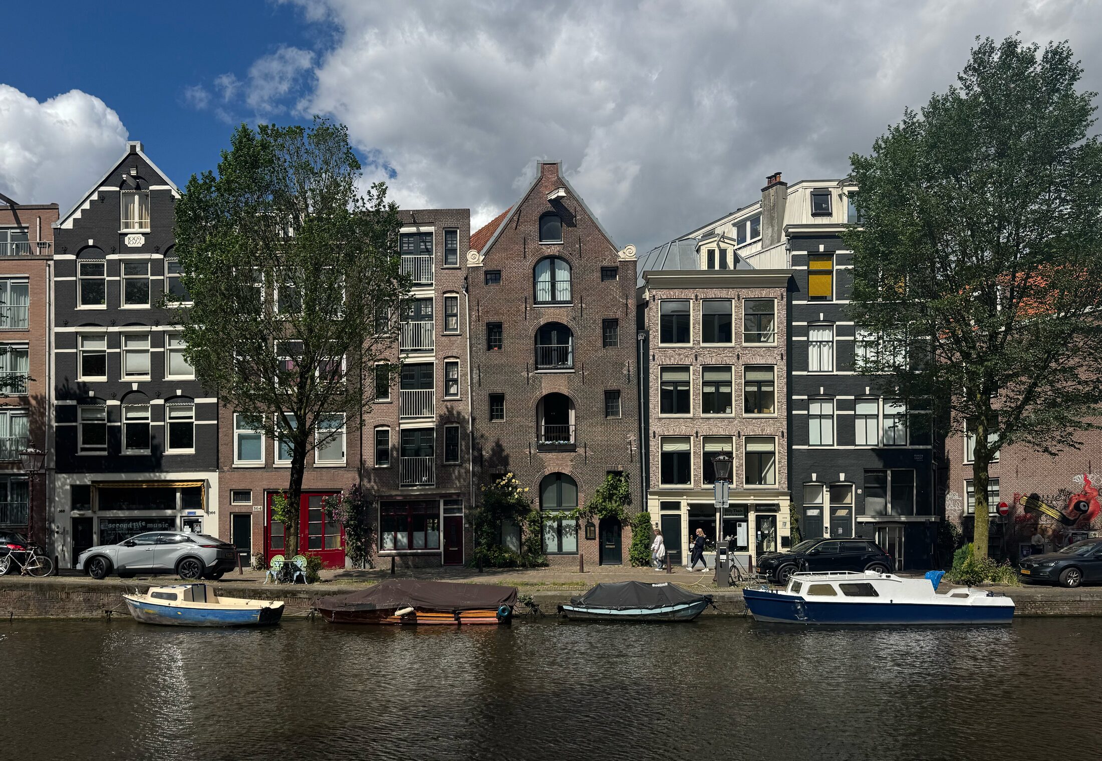 The row of historic canal-house facades on the Prinsengracht seen from across the water, with boats moored along the quay